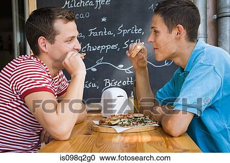 Stock Image - A gay couple having pizza. Fotosearch