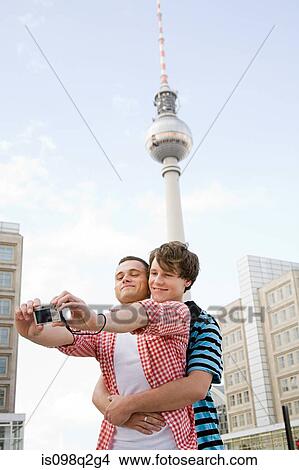 Picture - A gay couple photographing themselves. Fotosearch