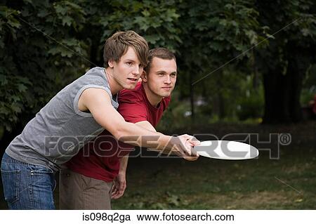 A gay couple playing frisbee View Large Photo Image Stock Image - A gay couple playing frisbee. Fotosearch