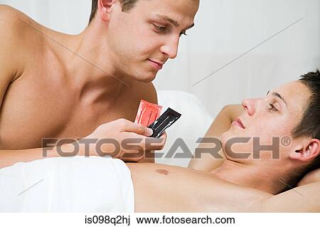 Stock Image - A man handing condoms to his partner. Fotosearch