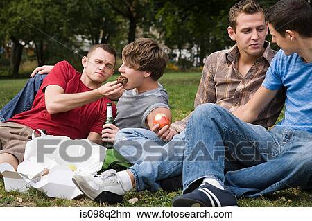 Friends having a picnic in the park View Large Photo Image Picture - Friends having a picnic in the park. Fotosearch
