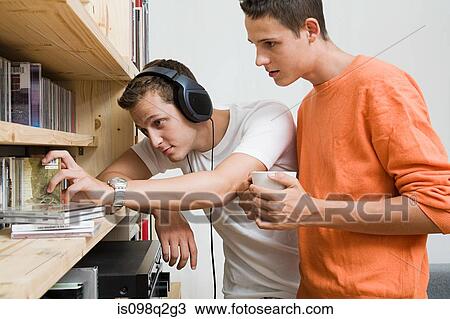 Two men looking at cds on a shelf View Large Photo Image Stock Image - Two men looking at cds on a shelf. Fotosearch