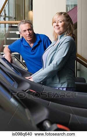 A man and woman using treadmills in the gym View Large Photo Image Stock Image - A man and woman using treadmills in the gym. Fotosearch