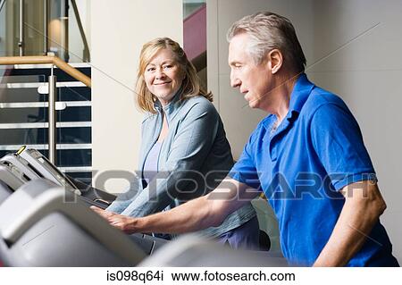 A man and woman using treadmills in the gym View Large Photo Image Stock Image - A man and woman using treadmills in the gym. Fotosearch