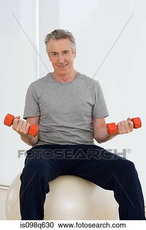 A man lifting dumbbells View Large Photo Image Stock Image - A man lifting dumbbells. Fotosearch