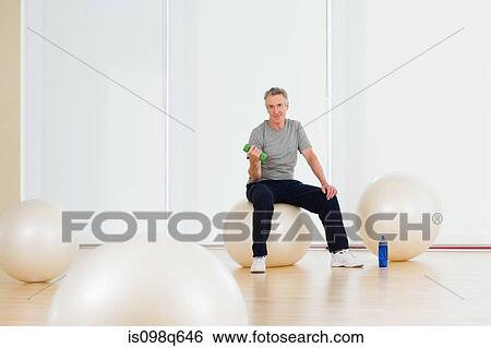 A man lifting dumbbells View Large Photo Image Stock Photograph - A man lifting dumbbells. Fotosearch