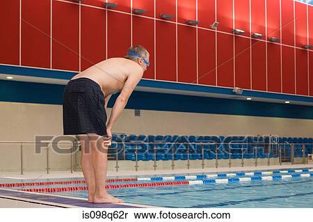 Stock Photography - A mature man about to dive into a swimming pool. Fotosearch