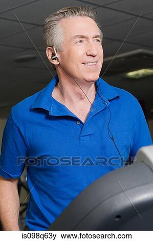 A mature man listening to music whilst exercising View Large Photo Image Stock Photo - A mature man listening to music whilst exercising. Fotosearch