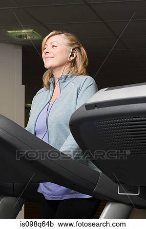 A mature woman listening to music whilst exercising View Large Photo Image Stock Image - A mature woman listening to music whilst exercising. Fotosearch