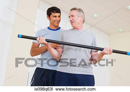 A personal trainer helping a man exercise View Large Photo Image Stock Image - A personal trainer helping a man exercise. Fotosearch