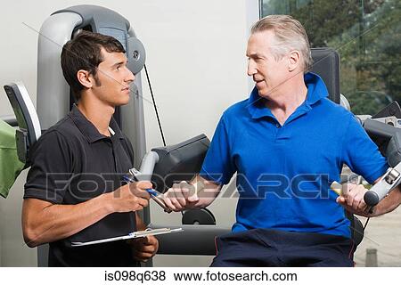 A personal trainer helping a man weightlift View Large Photo Image Stock Photo - A personal trainer helping a man weightlift. Fotosearch