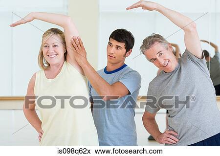 A personal trainer helping a woman in an exercise lesson View Large Photo Image Stock Photo - A personal trainer helping a woman in an exercise lesson. Fotosearch