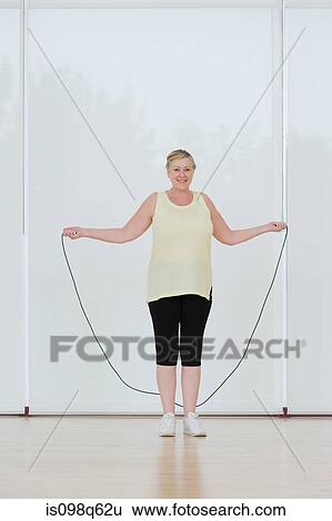 Portrait of a woman holding a skipping rope View Large Photo Image Stock Photograph - Portrait of a woman holding a skipping rope. Fotosearch