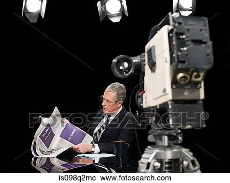 News presenter reading newspaper View Large Photo Image Stock Image - News presenter reading newspaper. Fotosearch