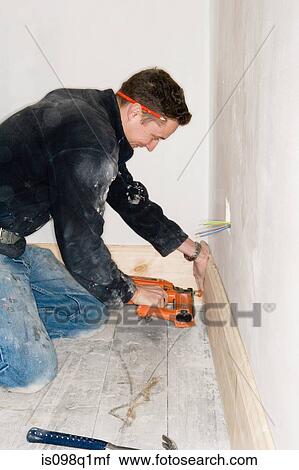 A builder attaching a skirting board to a wall View Large Photo Image Stock Image - A builder attaching a skirting board to a wall. Fotosearch