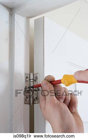 A builder fixing a door to a hinge View Large Photo Image Stock Photography - A builder fixing a door to a hinge. Fotosearch