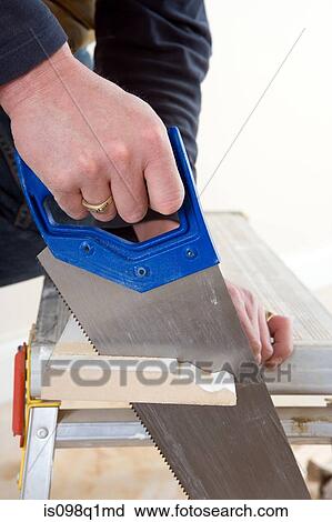 Stock Image - A carpenter sawing wood. Fotosearch