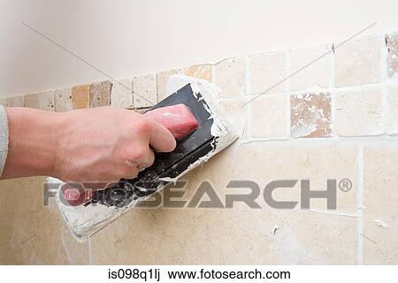 A decorator grouting tiles View Large Photo Image Stock Image - A decorator grouting tiles. Fotosearch