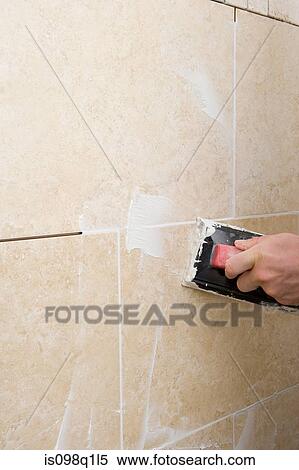 A decorator grouting tiles View Large Photo Image Stock Photography - A decorator grouting tiles. Fotosearch