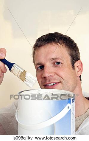 Stock Photo - A man holding a paintbrush. Fotosearch