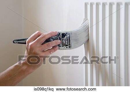 Stock Photography - A man painting a radiator. Fotosearch