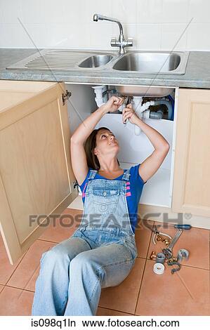 A young woman repairing a sink View Large Photo Image Picture - A young woman repairing a sink. Fotosearch