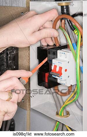 An electrician fixing a fuse box View Large Photo Image Stock Photograph - An electrician fixing a fuse box. Fotosearch