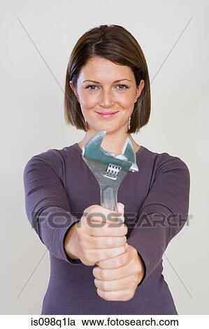 Portrait of a woman holding a spanner View Large Photo Image Stock Image - Portrait of a woman holding a spanner. Fotosearch
