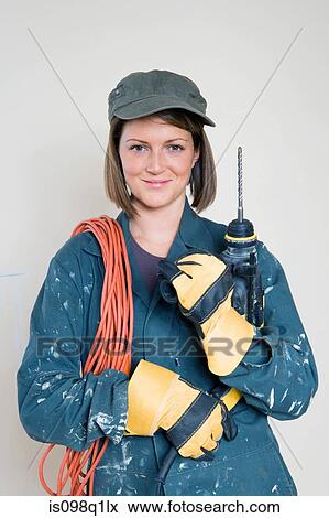 Portrait of a woman holding an electric drill View Large Photo Image Stock Photo - Portrait of a woman holding an electric drill. Fotosearch