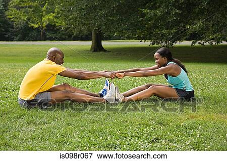 Stock Photo - Man and woman stretching in park. Fotosearch