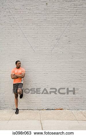 Stock Image - Runner leaning on wall. Fotosearch