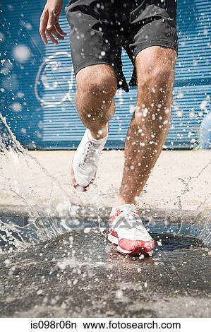 Picture - Runner stepping in puddle. Fotosearch