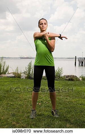 Stock Image - Runner stretching arm. Fotosearch