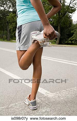 Stock Photo - Runner stretching leg. Fotosearch