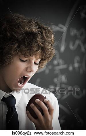Boy eating an apple View Large Photo Image Stock Photo - Boy eating an apple. Fotosearch