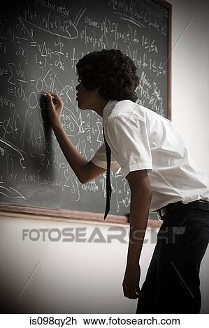 Boy writing on blackboard View Large Photo Image Stock Image - Boy writing on blackboard. Fotosearch