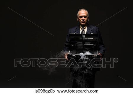 Stock Image - Businessman with smoking briefcase. Fotosearch
