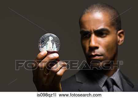 Stock Image - Businessman with snowglobe. Fotosearch