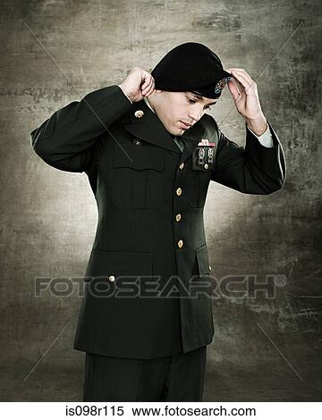 Stock Photography - A soldier adjusting his hat. Fotosearch