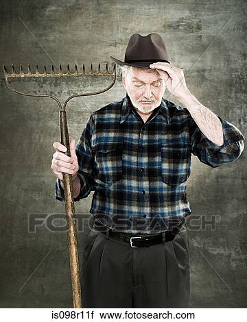 Portrait of a farmer holding a rake View Large Photo Image Stock Image - Portrait of a farmer holding a rake. Fotosearch