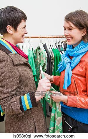 Stock Image - A lesbian couple looking at clothing. Fotosearch