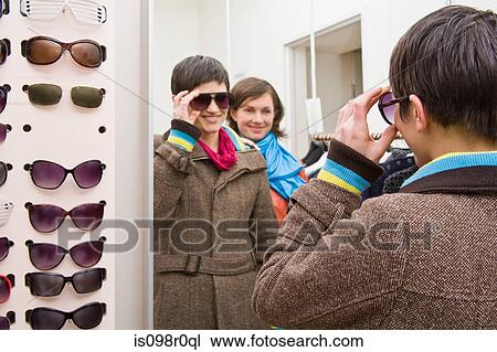 A woman trying on sunglasses View Large Photo Image Stock Image - A woman trying on sunglasses. Fotosearch