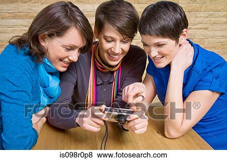 Friends looking at a camera View Large Photo Image Stock Photo - Friends looking at a camera. Fotosearch