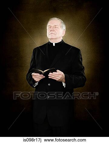 A priest holding a bible View Large Photo Image Stock Image - A priest holding a bible. Fotosearch