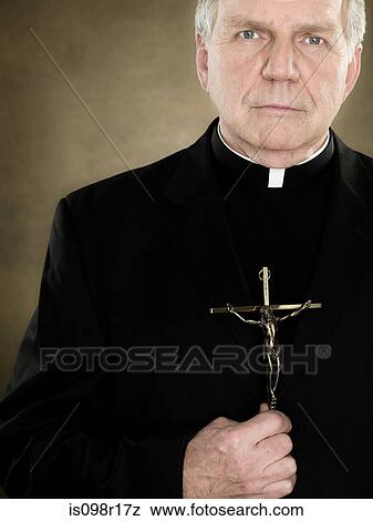 A priest holding a crucifix View Large Photo Image Stock Photo - A priest holding a crucifix. Fotosearch