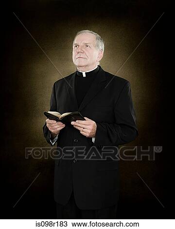 Portrait of a priest holding a bible View Large Photo Image Stock Image - Portrait of a priest holding a bible. Fotosearch