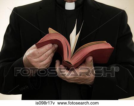 Priest holding a bible View Large Photo Image Stock Photo - Priest holding a bible. Fotosearch