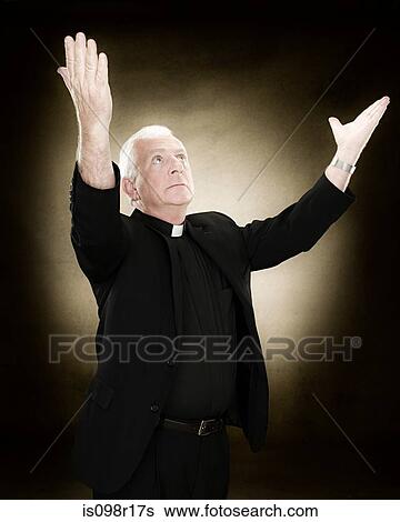 Priest with his arms raised View Large Photo Image Stock Photograph - Priest with his arms raised. Fotosearch
