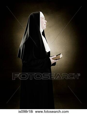 Stock Image - Profile of a nun praying. Fotosearch