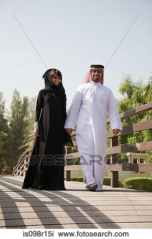 A couple walking along a bridge View Large Photo Image Stock Image - A couple walking along a bridge. Fotosearch